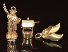 Three 9ct gold charms in the form of the Statue of Liberty, shoes and a well, 5.1g