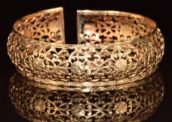 A yellow metal pierced bangle, tests as 18k gold, 23g