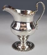 George V hallmarked silver helmet shaped cream jug in the Georgian style, with gadrooned edge,