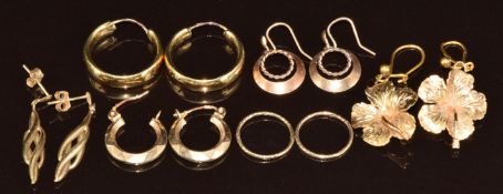 A pair of 14k gold hoops (1.8g), a pair of 10k gold earrings in the form of Hibiscus, (3g), and four