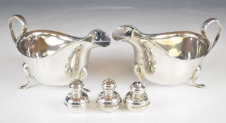 Pair of George V hallmarked silver sauce boats with scroll handles, raised on three feet, Birmingham