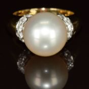 An 18k gold ring set with a South Sea pearl measuring 12mm and six round cut diamonds to each