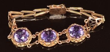 A 12k gold Egyptian bracelet set with three round cut synthetic colour change sapphires, 13.2g,