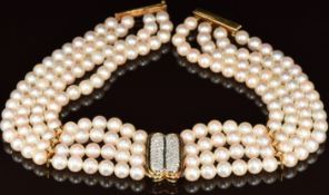 A four strand cultured pearl necklace with 18k gold pendant set with round cut diamonds, two 18k