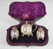 Victorian hallmarked silver three piece cruet set, decorated in the Chinese style, raised on ball