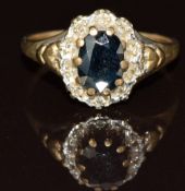 A 9ct gold ring set with an oval cut sapphire surrounded by diamonds, 2.2g, size J