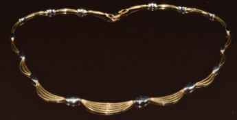 A 9ct gold bi-coloured necklace made up of marquise shaped and wave links, 12.3g, 42cm