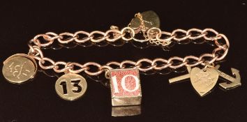 A 9ct rose gold bracelet with four 9ct gold charms including 10 shilling note, 'I love you' swivel