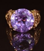 A 12k gold Egyptian ring set with a round cut synthetic colour change sapphire, 5.8g, size N