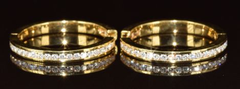 A pair of 18ct gold hoop earrings each set with twenty-two round cut diamonds, the total diamond