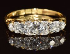 An 18ct gold ring set with five graduated diamonds with smaller diamonds between, the centre diamond