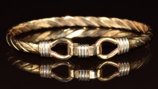 A 9ct gold bangle in a twisted design with hook clasp, 17g, 5.8 x 4.5cm
