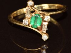 An 18ct gold ring set with an oval cut emerald and diamonds, 2.6g, size O