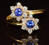 An 18k gold ring set with two tanzanites and diamonds in two floral clusters, 3.5g, size O