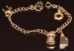 A 9ct gold charm bracelet with four 9ct gold charms including camel, post box, church and