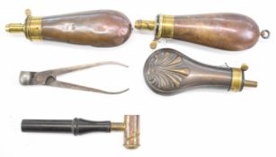 Five gun related tools and accessories comprising three copper and brass powder flasks including one