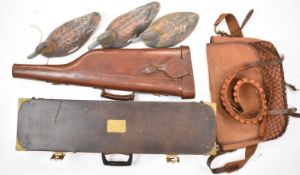 A collection of gun and shooting related items comprising two shotgun carry cases one a leather