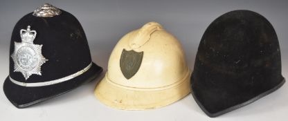 Two British police helmets, one with a Metropolitan Police Queen Elizabeth II badge the other