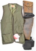 Three shooting and gun related items comprising a leather shotgun or rifle slip, leather cartridge