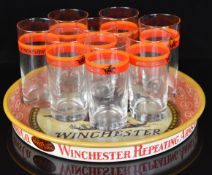 A set of eight Winchester drinking glasses (14cm tall) on Winchester Repeating Arms Co metal tray.