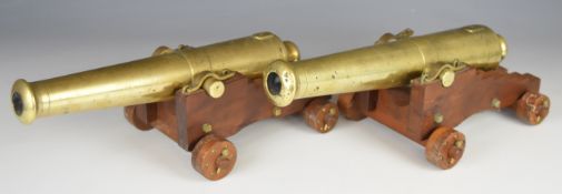 A pair of bronze desk or signalling cannon each, with 13 inch graduated barrel on wooden carriage,
