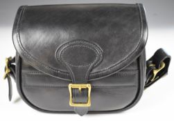 Leather shotgun cartridge bag with canvas strap.