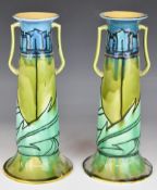 Mintons pair of Art Nouveau twin handled pedestal pottery vases with tube lined decoration,