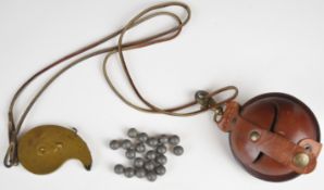 Brass rotary percussion cap dispenser stamped 'TDC' and a leather musket ball holder.