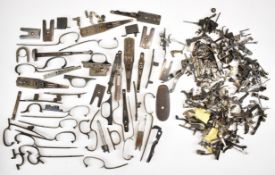 A collection of shotgun and rifle parts including triggers, top levers, extractors, locks, trigger