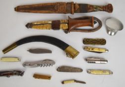 Two tribal daggers both with sheaths, longest blade 25cm, together with eleven pocket / folding