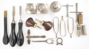 A collection of vintage gun tools and accessories including two James Purdey striker disc keys,