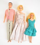 Three 1960's Mattel Barbie dolls comprising Barbie, Ken and Skipper, all in vintage outfits.
