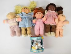 Five Mattel Cabbage Patch dolls together with a boxed Furby Babies toy by Tiger.