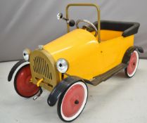 Brum pressed steel children's pedal car with yellow body, red hubs, painted eyes and crank handle,