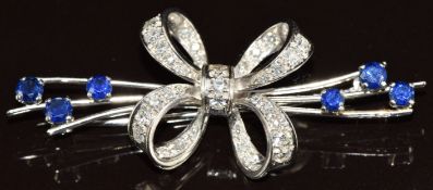 An 18k white gold brooch in the form of a stylised bow set with diamonds totalling approximately 1.