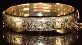 A 9ct gold bangle with scrolling decoration, 17.2g, 6 x 5.5cm
