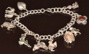 A silver charm bracelet with nine silver charms including elephant, lion, pixie, hedgehog, etc, 25g