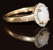 A 9ct gold ring set with an opal surrounded by diamonds, 2g, size I