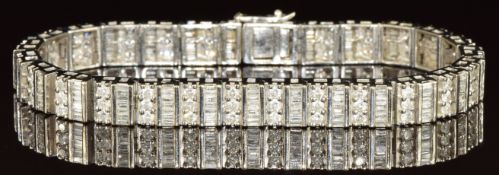 A 10k white gold bracelet set with round and baguette cut diamonds, the total diamond weight