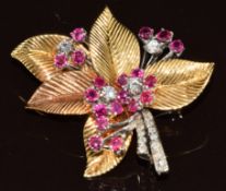 An 18k gold floral brooch set with rubies and diamonds with textured leaves, 16.2g, 3.5 x 3.6cm