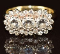 An 18ct gold ring set with three diamonds each approximately 0.3ct, surrounded by further