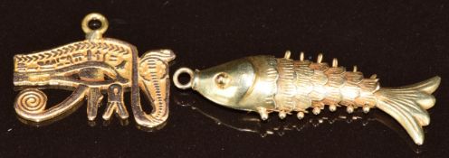 A 14k gold articulated fish pendant/ charm (1.2g, 2.7cm) and a yellow metal Egyptian pendant (1.3g)