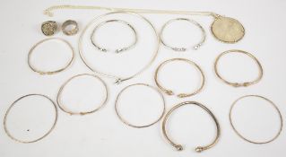 A collection of silver jewellery including two rings, ten bangles, mounted 25 dollar coin, chain and