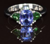 An 18ct white gold ring set with a cushion cut tanzanite of approximately 2.4ct and two tsavorite