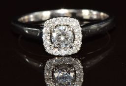 An 18ct white gold ring set with a round cut diamond surrounded by further diamonds, the total
