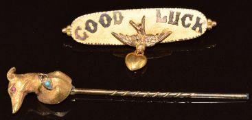 A Victorian 9ct gold 'Good Luck' brooch in the form of a swallow holding a drop heart (Birmingham