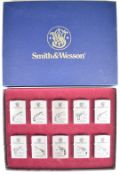 Ten Smith & Wesson limited edition brushed chrome Zippo lighters, each with a different model pistol