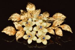 An 18ct gold brooch in the form of flowers and leaves set with enamel and sapphires, 12g, 4.5 x 3cm