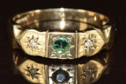 A 9ct gold ring set with a round cut emerald and two diamonds in star settings, 2.3g, size M