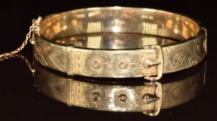 A 9ct gold bangle in the form of a buckle with engraved floral decoration, 14.4g, 5.8cm